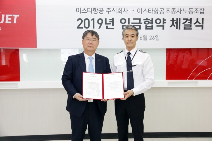 최종구 이스타항공 대표이사(왼쪽)와 신영근 조종사노동조합 위원장이 2019 임금협약 체결식에서 서명식을 갖고 기념촬영을 하고 있다. 사진=이스타항공 제공