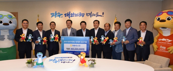 농협중앙회 김병원 회장이 이용섭 광주광역시장에게 광주세계수영선수권대회 성공기원 기부금 2억원을 전달하고 있다.