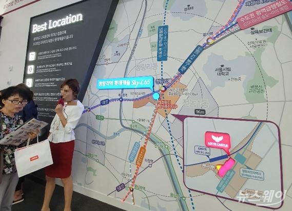 19일 오전 ‘청량리역 롯데캐슬 SKY-L65’ 모델하우스에 설치된 단지 주변 교통편 지도 앞에서 분양관계자가 수요자에게 단지에 대한 설명을 진행하고 있다. 사진=이수정 기자