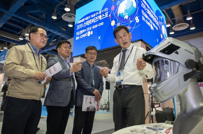 8일 서울 코엑스에서 열린 ‘2019 대·중소기업 상생협력 스마트비즈엑스포’에 참가한 산업용 안전 보호구 제조 기업 ‘오토스윙’의 허문영 대표(오른쪽 첫번째)가 관람객들에게 제품을 소개하고 있다. 사진=삼성전자 제공