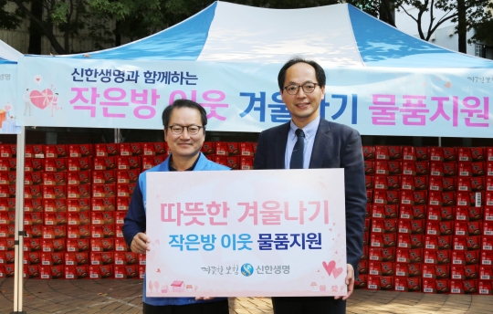 지난 24일 서울역 쪽방상담소 나눔터에서 쪽방촌 주민들에게 라면을 전달한 성대규 신한생명 사장(왼쪽)이 김갑록 쪽방상담소장과 기념촬영을 하고 있다. 사진=신한생명