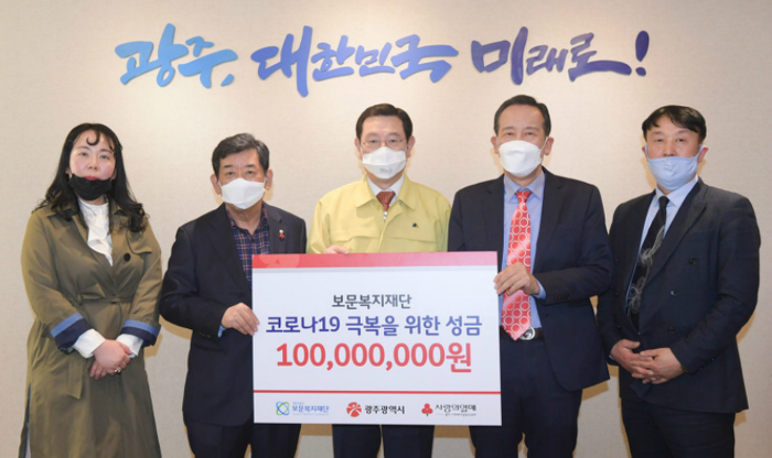 정영헌 보문복지재단 이사장(오른쪽 두번째)이 이용섭 광주광역시장에게 코로나19 극복 위해 써달라며 1억원 성금을 전달하고 있다.