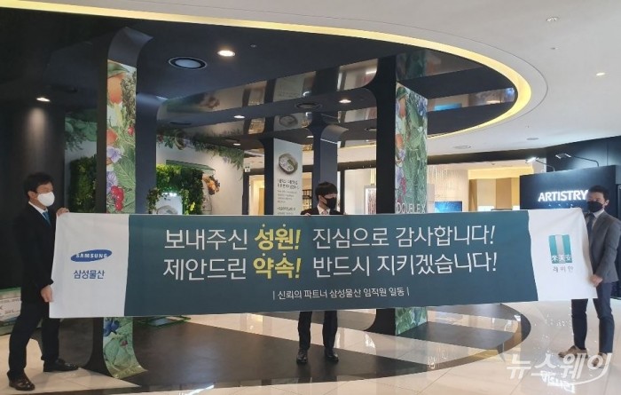 23일 오후 4시30분께 신반포15 투표 결과가 삼성물산의 압승으로 나온 뒤, 삼성물산 관계자들이 플래카드를 펼쳐보이고 있다. 사진=이수정 기자