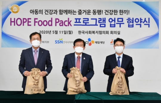 정길근 CJ제일제당 부사장(왼쪽부터), 서상목 한국사회복지협의회장, 남세도 전국지역아동센터협의회 이사장이 ‘HOPE Food Pack’을 포장한 후 기념촬영을 하고 있다. 사진=한국사회복지협의회