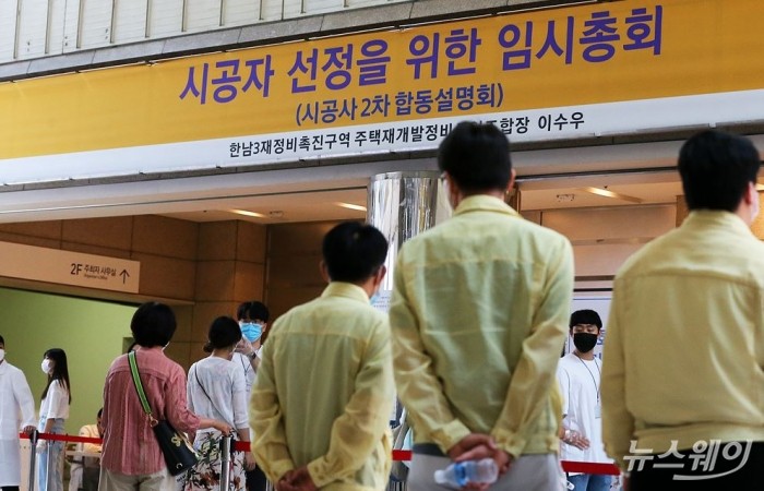 21일 오후 서울특별시 강남구 코엑스 1층에서 개최된 한남3구역 시공사 선정 총회장 앞에 노란 점퍼를 입은 강남구청 재난안전과 관계자들이 행사가 시작되기 전 도착해 상황을 지켜보고 있다. 사진=이수길 기자