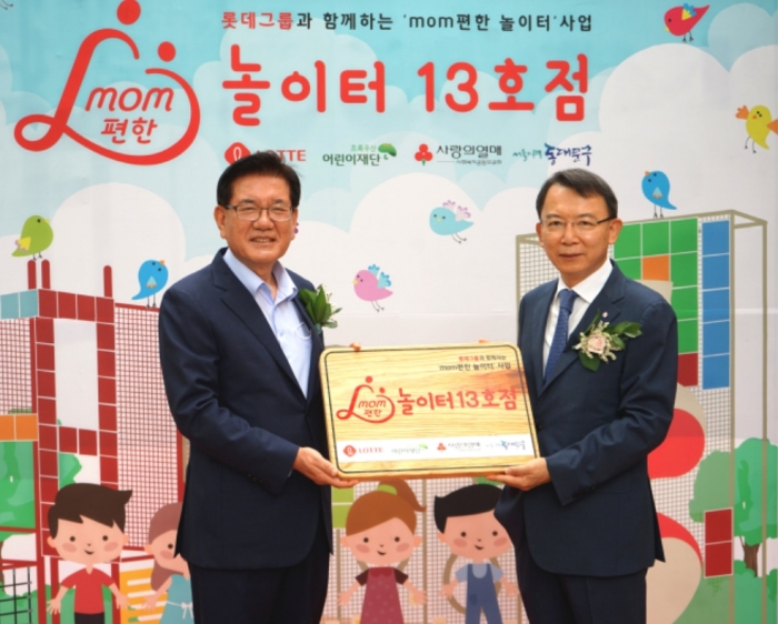 롯데는 2일 서울시 동대문구 휘경동 새싹마을마당에 ‘mom편한 놀이터’ 13호점을 오픈했다. 이날 오픈 행사에 참여한 오성엽 롯데지주 커뮤니케이션실 사장(오른쪽)과 유덕열 동대문구청장(왼쪽)이 기념촬영을 하고 있다. 사진=롯데지주 제공