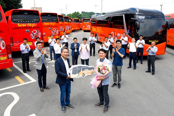 기아차 B2B 사업실장 윤승규 상무(왼쪽)와 뉴부자관광 원동호 대표(오른쪽)가 ‘그랜버드 슈퍼 프리미엄’ 1호차 전달식을 갖고 기념촬영을 하는 모습. 사진=기아자동차 제공