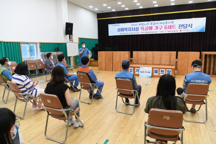 광양제철소 희망나무 목공예 재능봉사단이 24일 손수 나무로 제작한 요가매트 보관함과 통기타 보관함을 중마노인복지관에 전달하는 행사를 열고 있다.