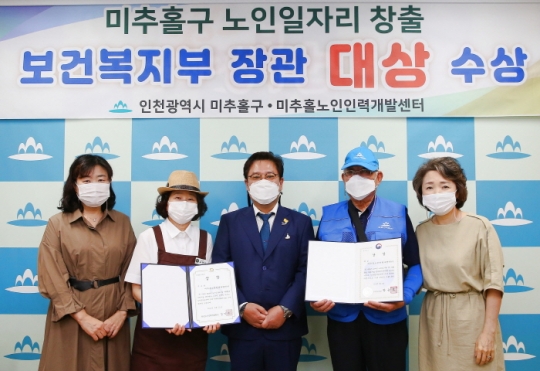 김정식 미추홀구청장(가운데)이 전국 노인일자리 및 사회활동지원사업 평가대회 대상 수상을 기념하고 있다.