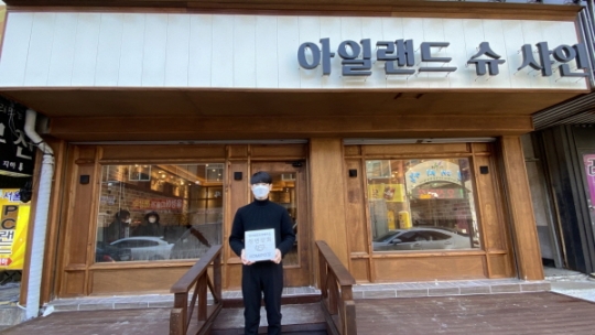 중부발전이 지원한 청년창업 점포 아일랜드 슈샤인 대표가 청년상회 현판을 들고 기념촬영을 하고 있다.