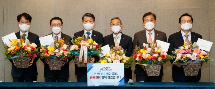 은성수 금융위원장이 16일 오후 서울 명동 은행회관 내 뱅커스클럽에서 5대 금융지주 회장단과 만나 간담회를 했다. 회의 참석자들이 은성수 위원장이 선물한 꽃바구니를 들고 기념촬영을 하고 있다. 사진 왼쪽부터 손병환 농협금융지주 회장, 조용병 신한금융지주 회장, 은성수 금융위원장, 윤종규 KB금융지주 회장, 김정태 하나금융지주 회장, 손태승 우리금융지주 회장. 사진=금융위원회 제공