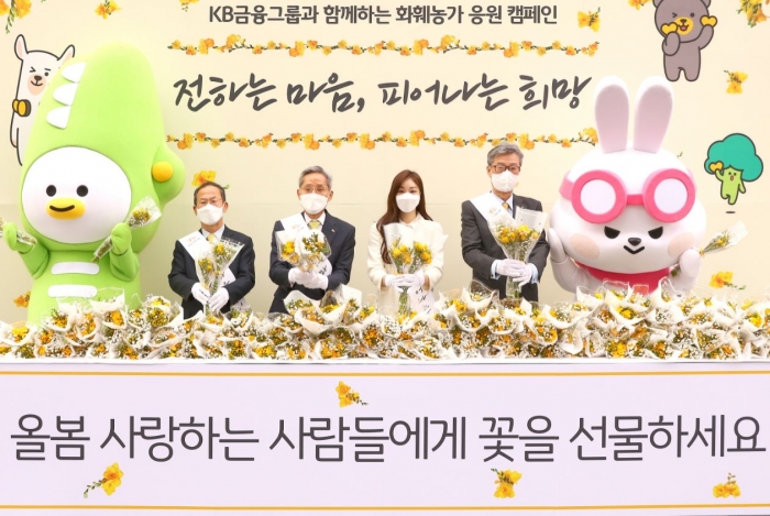 15일 오전 서울 여의도역 인근에서 (왼쪽부터)양종희 KB금융그룹 부회장, KB금융그룹 윤종규 회장, 김연아 피겨스케이터, KB국민은행 허인 은행장이 화훼 농가 돕기 캠페인인 ‘전하는 마음, 피어나는 희망’ 행사에 참여해 기념 사진을 찍고 있다.