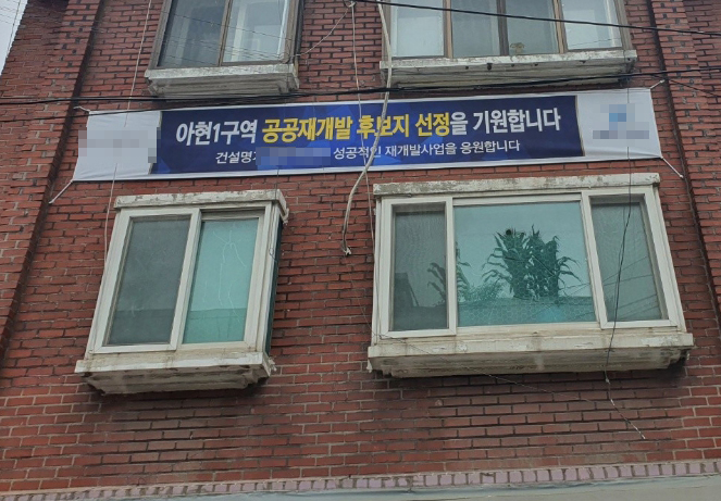 아현1구역이 공공재개발 후보지로 선정된 후 건설업계에서는 현수막을 설치하고 홍보관련 물품을 전달하는 등 주민들과의 물밑 접촉을 시작했다. 사진=장귀용 기자