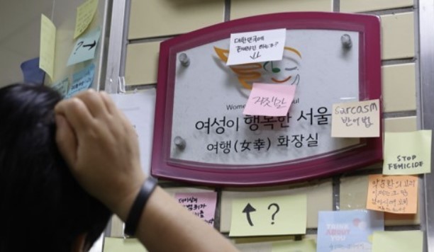 '역무원 스토킹 피살 사건'이 발생한 서울 지하철 2호선 신당역에서 지난 20일 한 시민이 여자 화장실 입구에 부착된 '여성이 행복한 서울' 프로젝트 푯말에 붙여진 메시지를 보고 있다. 사진/ 연합뉴스 제공