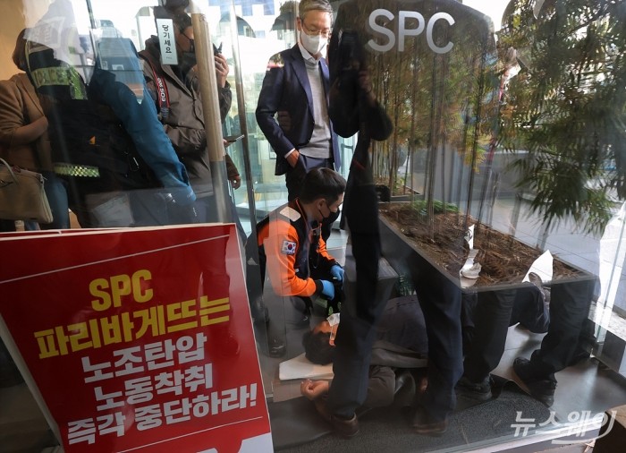 SPC그룹이 21일 오전 서울 서초구 SPC 본사에서 계열사 SPL의 평택 제빵공장 20대 여자노동자 사망 사고 관련 긴급 대국민 사과 및 기자회견장을 진행한 가운데 본사 정문에서 기자회견에 참석하려는 노동자들과 이를 막으려는 SPC직원들간의 몸싸움에서 부상자가 발행해 119구급대가 출동해 환자를 살피고 있다. 사진=이수길 기자 leo2004@newsway.co.kr