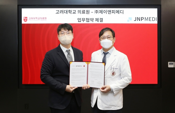 함병주 의학연구처장(좌측)과 정권호 대표(우측)이 협약서에 서명 후 기념촬영을 하고있다.