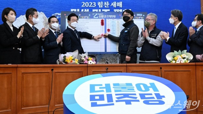 이재명 더불어민주당 대표와 서광순 희망연대본부 공동본부장, 박명근 SK케비지부장을 비롯한 의원들이 25일 오전 서울 여의도 국회에서 열린 을지로위원회 상생 꽃달기 행사에서 기념촬영을 하고 있다. 사진=강민석 기자 kms@newsway.co.kr