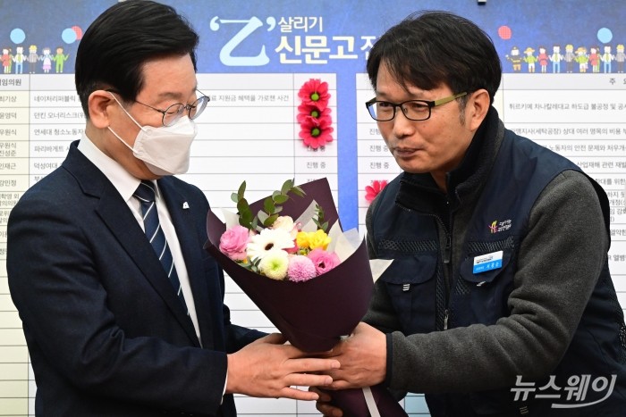 이재명 더불어민주당 대표가 25일 오전 서울 여의도 국회에서 열린 을지로위원회 상생 꽃달기 행사에서 서광순 희망연대본부 공동본부장으로부터 꽃다발을 받고 있다. 사진=강민석 기자 kms@newsway.co.kr