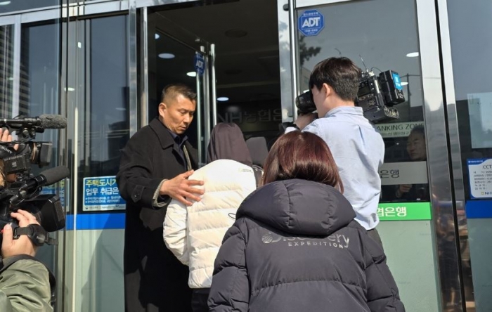 길성주 ELS피해자모임 위원장이 15일 오후 서울 서대문 농협은행 본점 앞에서 시위 이후 계좌 잔액 인출(단체 뱅크런 시위)을 위해 줄을 서있던 ELS 투자자들을 영업점 내부로 안내하고 있다. 사진=이병현 기자 bottlee@