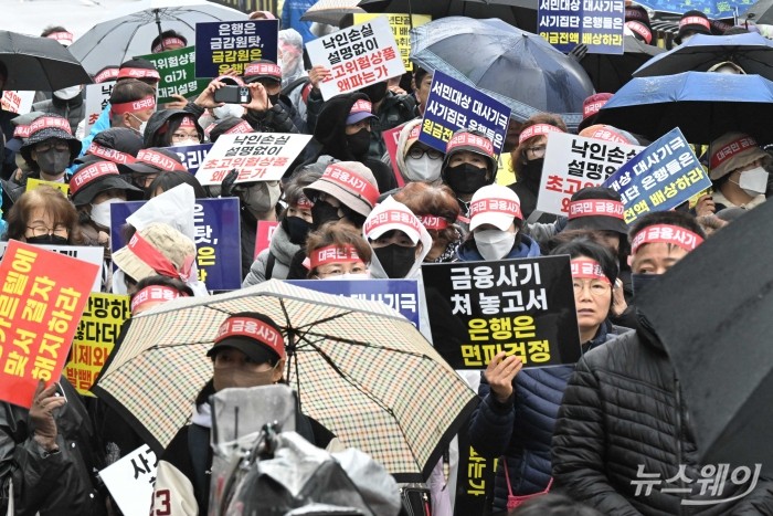 홍콩지수ELS피해자모임 관계자들이 29일 오후 서울 여의도 KB국민은행 신관 앞에서 '대국민 금융 사기 계약 원천 무효' 관련 집회를 열고 손팻말을 들고 있다. 사진=강민석 기자 kms@newsway.co.kr