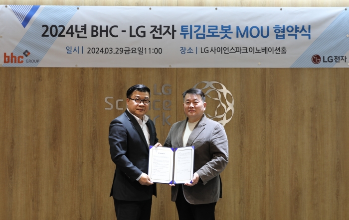 LG전자 서영덕 커머셜기업1담당 상무(왼쪽)와 bhc 문상만 가맹사업본부장이 튀김로봇 공동 사업 MOU 체결 기념사진을 촬영하고 있다