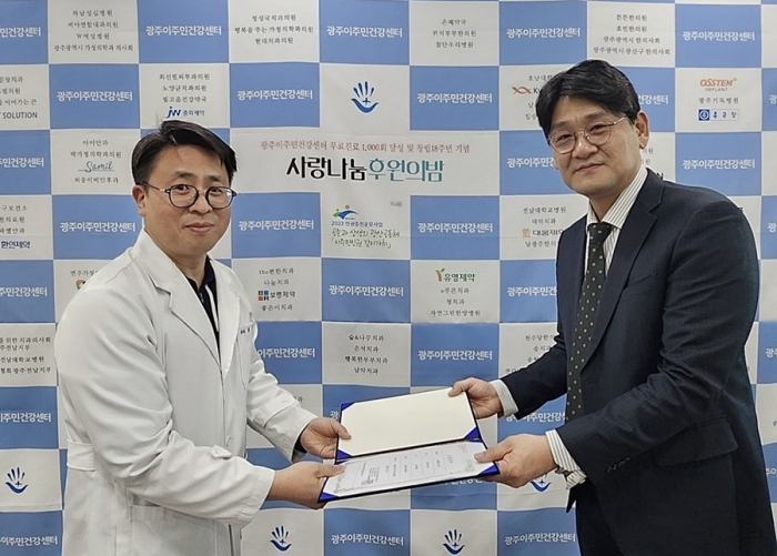 광주이주민건강센터 '사랑나눔 후원의밤'에서 임선 온라인팜 약국 영업부 이사(오른쪽)가 최창옥 센터 등기이사에게 제이브이엠 의약품 자동 조제기 기증서를 전달하고 있다. 사진=한미그룹 제공