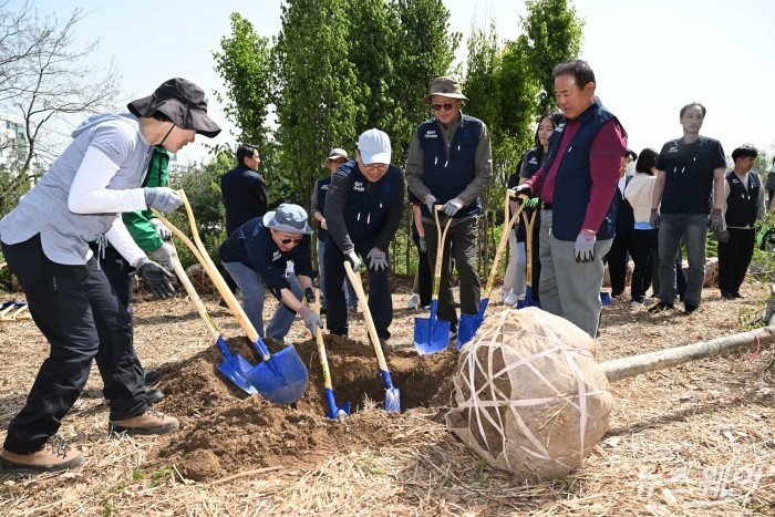(오른쪽 세 번째)박일준 대한상공회의소 상근부회장과 (왼쪽 세 번째)임상섭 산림청 차장을 비롯한 대한상의 임직원이 18일 오전 서울 양천구 온수공원 2지구에서 열린 'ERT 도시숲 나무심기'에서 분에 산딸 나무를 심기 위해 삽을 떠고 있다. 사진=강민석 기자 kms@newsway.co.kr