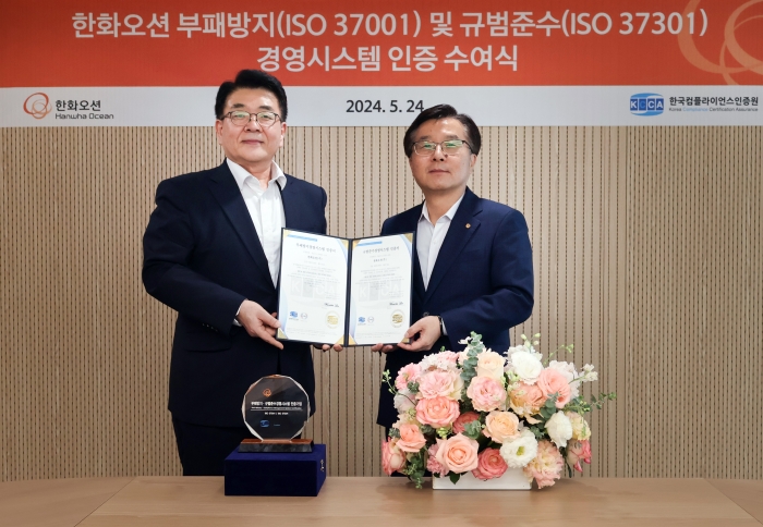 지난 24일 한화오션 권혁웅 대표이사(오른쪽)와 한국컴플라이언스인증원 이원기 원장이 참석한 가운데 장교동에 위치한 한화빌딩에서 'ISO 37001, 37301' 인증서 수여 후 기념촬영을 하고 있다. 사진=한화오션 제공
