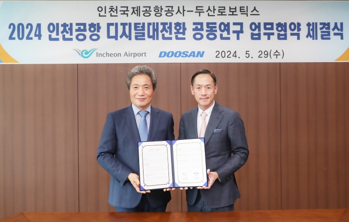 인천국제공항 디지털 전환 추진 협업 체계 구축'을 위한 업무협약식이 끝나고 두산로보틱스 박인원 대표(오른쪽)와 인천국제공항공사 이학재 사장이 기념사진을 촬영하고 있다. 사진=두산로보틱스 제공