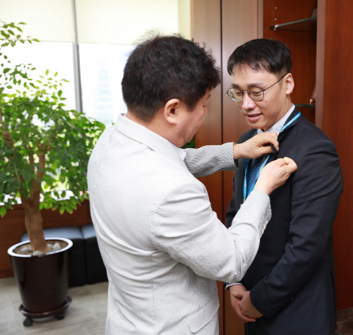 김윤식 신협중앙회장이 특별 채용 신규직원에게 사원증을 걸어주고 있다. 사진=신협중앙회 제공