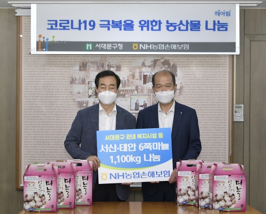 지난 27일 서울 서대문구청을 방문한 최창수 NH농협손해보험 대표(오른쪽)가 문석진 서대문구청장에게 소외계층을 위한 마늘을 전달한 뒤 기념촬영을 하고 있다. 사진=NH농협손해보험